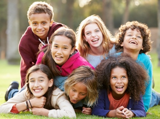 Group of smiling kids laying in grass