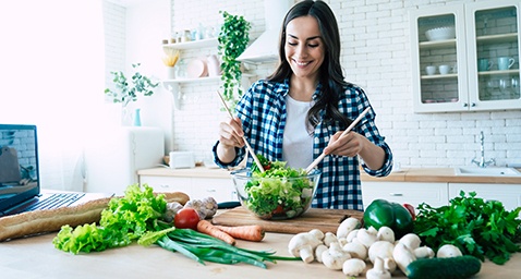 Woman preparing healthy salad in kitchen at home