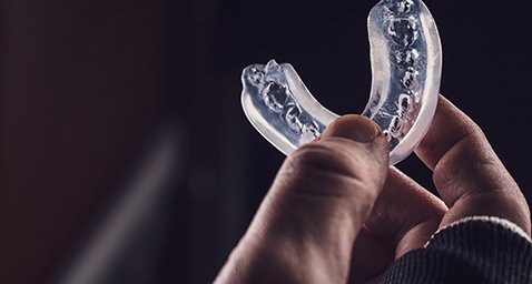 Closeup of patient holding clear mouthguard